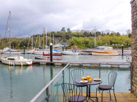 An outdoor area with a table and chairs overlooking a marina at Spanish Boathouse in Brixham