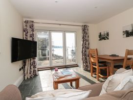 A living room with a television and dining area at Spanish Boathouse in Brixham