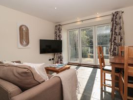 A living room with a sofa and television at Spanish Boathouse in Brixham