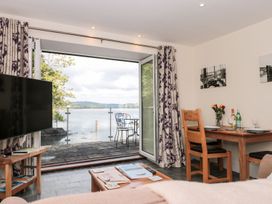 A living room with a television and a dining table at Spanish Boathouse in Brixham