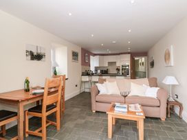 An open plan living area with a dining table and kitchen in the Spanish Boathouse Brixham
