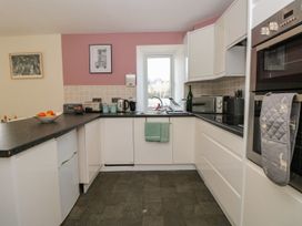 A kitchen with a sink, oven, and window at Spanish Boathouse in Brixham