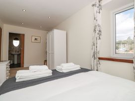 A bedroom with a bed and wardrobe at Spanish Boathouse in Brixham