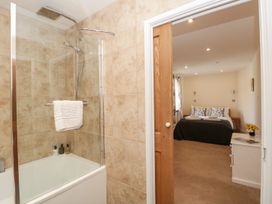 A bathroom with a shower and a door leading to a bedroom at Spanish Boathouse in Brixham