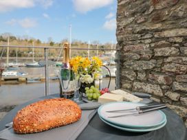 A table with bread, cheese, champagne, and flowers at Spanish Boathouse in Brixham