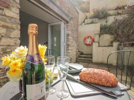 An outdoor dining table with champagne, glasses, and bread at Spanish Boathouse in Brixham