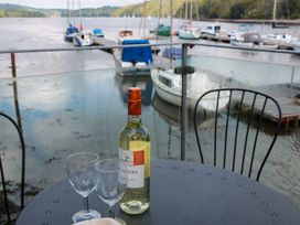 A table with a wine bottle and glasses overlooking the boats at Spanish Boathouse in Brixham