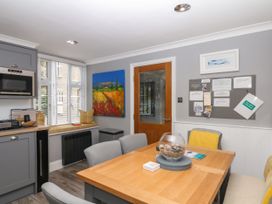 A kitchen with a dining table and chairs at 12 Courtyard Cottage at Sheplegh Court Totnes