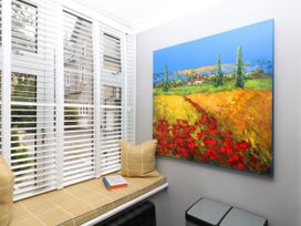 A snug with a window seat and artwork on the wall at 12 Courtyard Cottage at Sheplegh Court in Totnes