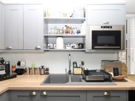A kitchen with a sink and microwave at 12 Courtyard Cottage at Sheplegh Court, Totnes
