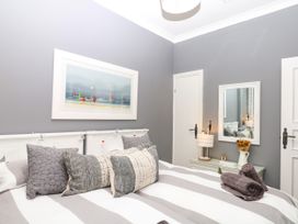 A bedroom with a bed and decorative pillows at 12 Courtyard Cottage at Sheplegh Court in Totnes