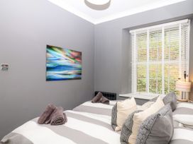 A bedroom with two beds and decorative pillows at 12 Courtyard Cottage at Sheplegh Court in Totnes