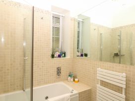 A bathroom with a shower and bath at 12 Courtyard Cottage at Sheplegh Court Totnes