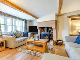 A living room with a fireplace, sofa and coffee table at The Quirky Cottage in Eamont Bridge near Ullswater