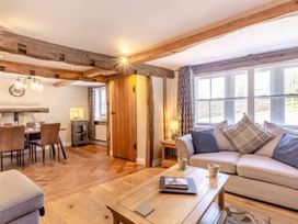 A living room with a sofa and dining area at The Quirky Cottage Eamont Bridge near Ullswater