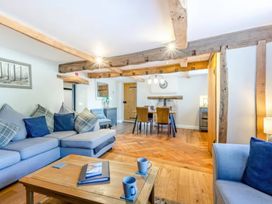 A living room with a sofa and dining area at The Quirky Cottage in Eamont Bridge near Ullswater