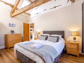 A bedroom featuring a bed with pillows and a bedside table at The Quirky Cottage in Eamont Bridge near Ullswater
