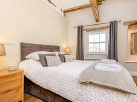 A bedroom with a bed and bedside table at The Quirky Cottage in Eamont Bridge near Ullswater