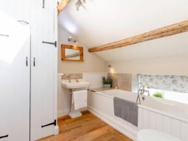 A bathroom with a bathtub and sink at The Quirky Cottage in Eamont Bridge near Ullswater