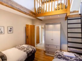 A bedroom with twin beds and a staircase at The Quirky Cottage near Eamont Bridge