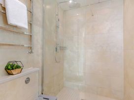 A shower area with towel rack and plant at The Quirky Cottage Eamont Bridge near Ullswater