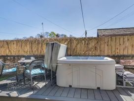 An outdoor area with a hot tub and chairs at The Quirky Cottage Eamont Bridge near Ullswater