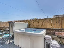 A hot tub by a wooden fence at The Quirky Cottage Eamont Bridge near Ullswater