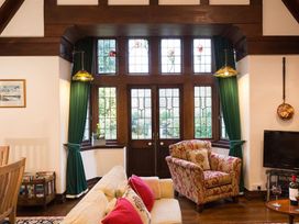A living room with a sofa, chair, and television at White Gables in Ambleside
