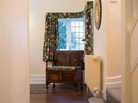 A hallway with a bench and curtains at White Gables in Ambleside