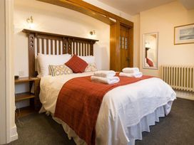 A bedroom with a bed and a mirror at White Gables in Ambleside