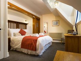 A bedroom with a bed and dresser at White Gables in Ambleside