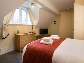 A bedroom with a bed and dresser at White Gables in Ambleside