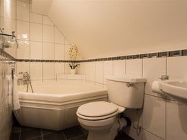 A bathroom with a bathtub, toilet and sink at White Gables in Ambleside