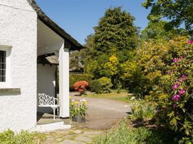A garden with flowers and a bench at White Gables in Ambleside