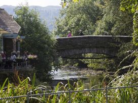 A bridge over a river with people walking at White Gables in Ambleside
