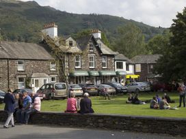 A view of a public area with people sitting and buildings at White Gables Ambleside