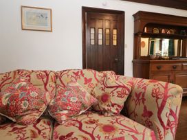 A living room with a sofa and wooden cabinet at White Gables in Grasmere