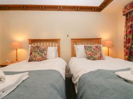 A bedroom with two beds and a lamp at White Gables in Grasmere