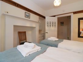 A bedroom with twin beds and a chair at White Gables in Grasmere