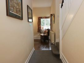 A hallway with framed pictures and a chair at White Gables in Grasmere