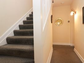 A staircase with a light fixture in a hallway at White Gables in Grasmere