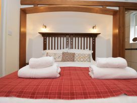 A bedroom with a bed and towels at White Gables in Grasmere