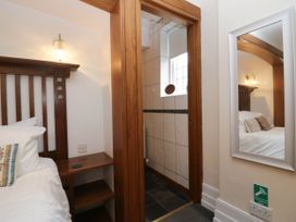 A bedroom with a bed and a shower visible at White Gables in Grasmere