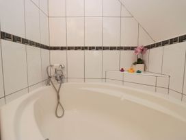 A bathroom with a bathtub and faucets at White Gables in Grasmere