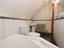 A bathroom with a bathtub, toilet, sink, and radiator at White Gables in Grasmere