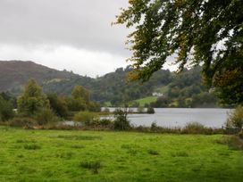 A lake with grass and trees at White Gables in Grasmere