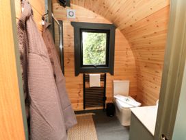 A bathroom with a toilet, shower, and towel rack at Windy Ridge Lodge in Egton