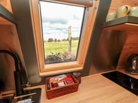 A kitchen view with a window showing a field at Windy Ridge Lodge in Egton