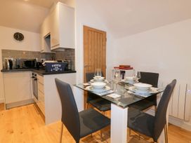 A kitchen with a dining table and chairs at Fishermans Loft in Mevagissey