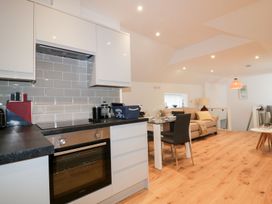 A kitchen with appliances and seating area at Fishermans Loft in Mevagissey